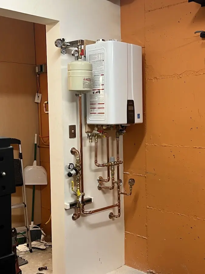 Plumbing technician inspecting water heater connections in Redmond